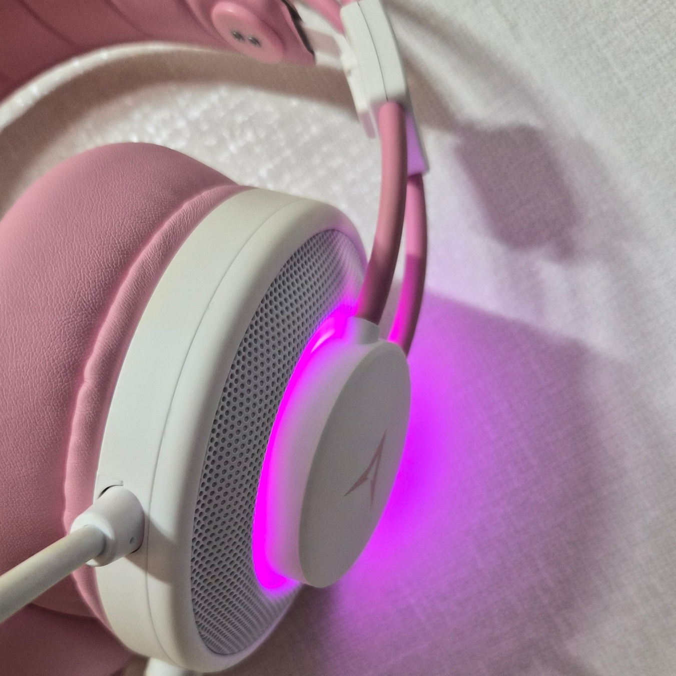 ABKO N550 이어컵 옆면 RGB 라이팅, 전원이 켜진 상태로 핑크빛이 발광하는 클로즈업